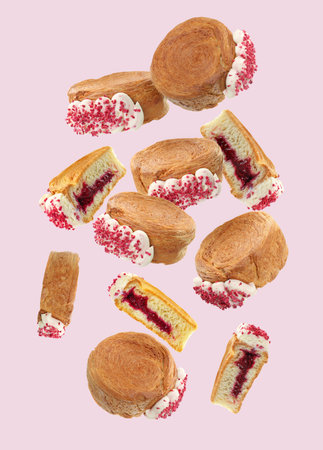 Delicious round croissants in air on pink background. Puff pastryの写真素材
