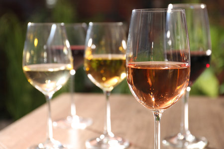 Different tasty wines in glasses against blurred background, closeupの写真素材