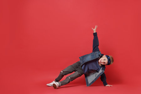 Happy little boy dancing on red background. Space for textの写真素材