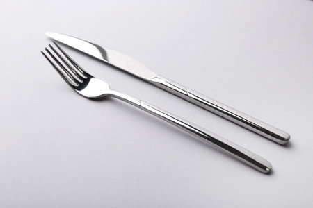 Stylish cutlery. Silver knife and fork on gray backgroundの写真素材