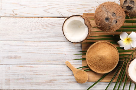 Coconut sugar, palm leaves, fruits and bamboo mat on wooden rustic table, flat lay. Space for textの写真素材