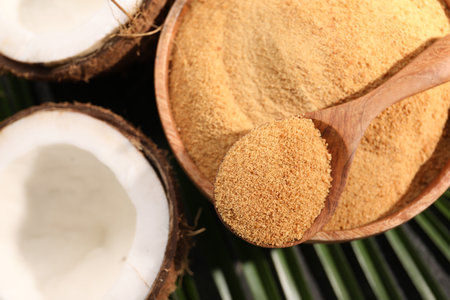 Spoon with coconut sugar, bowl and fruits on table, flat layの写真素材