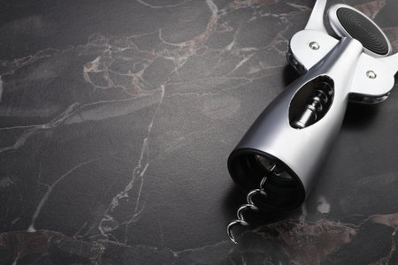 One wing corkscrew on black marble table. Space for textの写真素材