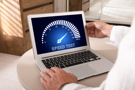 Speed test. Man using laptop at table, closeup