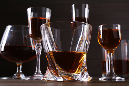 Different delicious liqueurs in glasses on wooden table, closeupの写真素材
