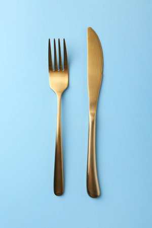 Stylish cutlery on light blue table, top viewの写真素材