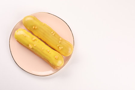 Delicious eclairs covered with glaze on white background, top view