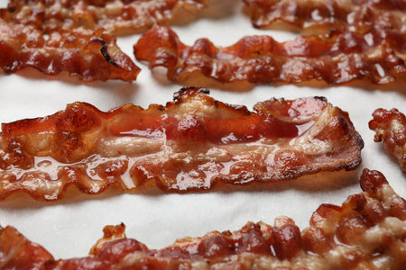 Slices of tasty fried bacon on white table, closeupの写真素材