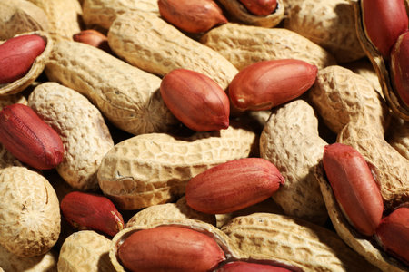 Many fresh unpeeled peanuts as background, closeup