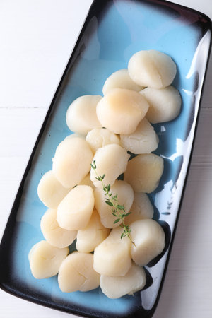 Fresh raw scallops and thyme on white wooden table, top viewの写真素材