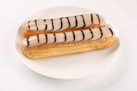 Delicious eclairs covered with glaze on white backgroundの写真素材
