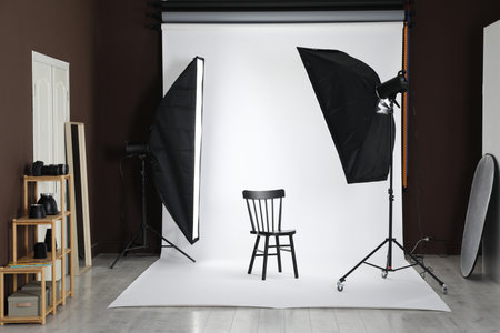 White photo background, chair and professional lighting equipment in studioの写真素材