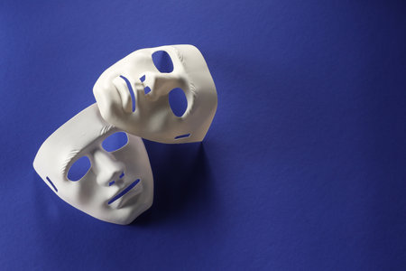 Theater arts. White masks on blue background, top view. Space for textの写真素材