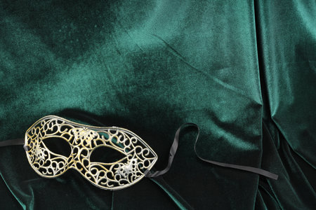 Theater arts. carnival mask on green fabric, top view. Space for textの写真素材