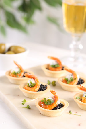 Delicious canapes with shrimps and black caviar on table, closeupの写真素材