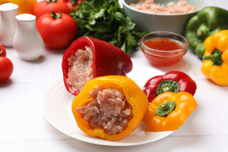 Raw stuffed peppers, ground meat and ingredients on white tableの写真素材
