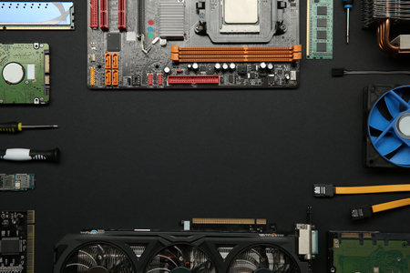 Frame of graphics card and other computer hardware on black background, flat lay. Space for textの写真素材