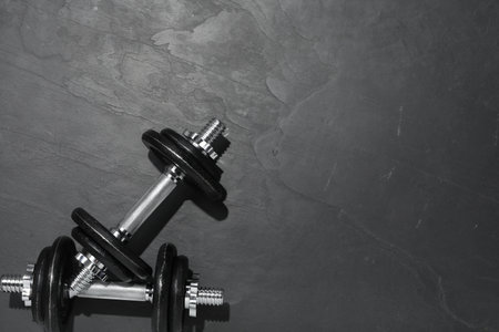Barbells on dark textured floor, top view. Space for textの写真素材