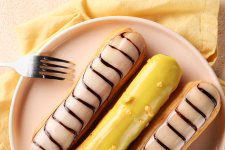 Different tasty glazed eclairs served on table, top viewの写真素材