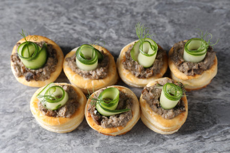 Delicious puff pastry with mushrooms, cucumber and dill on gray table, above viewの写真素材