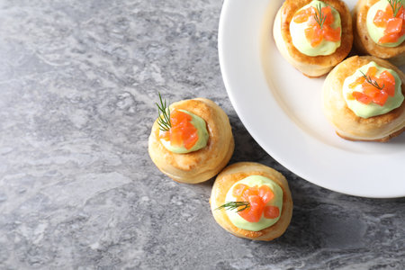 Delicious puff pastry with avocado cream, salmon and dill on gray table, top view. Space for textの写真素材