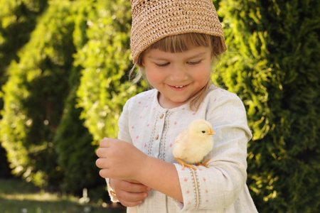 Cute little girl with chick outdoors. Baby animalの写真素材