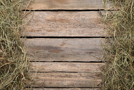 Frame made of dried hay on wooden table, top view. Space for textの写真素材