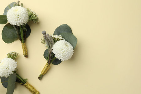 Many stylish boutonnieres on beige background, flat lay. Space for textの写真素材