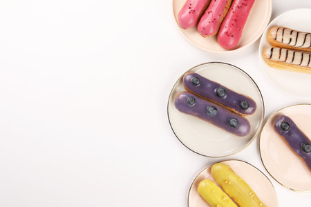 Delicious eclairs covered with glaze on white background, top viewの写真素材