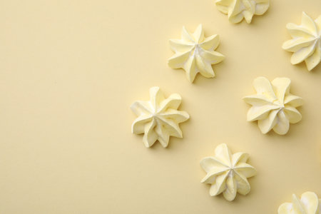 Delicious meringue cookies on beige background, flat lay. Space for textの写真素材
