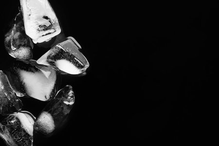 Pieces of crushed ice on black mirror surface, space for textの写真素材