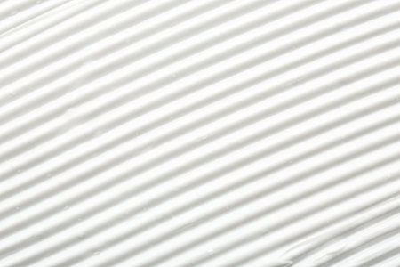 Texture of face care cream as background, top view