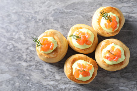 Delicious puff pastry with avocado cream, salmon and dill on gray table, top viewの写真素材