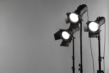 Gray photo background and professional lighting equipment in studio. Space for text