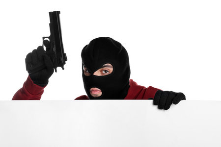 Thief in balaclava with gun on white backgroundの写真素材