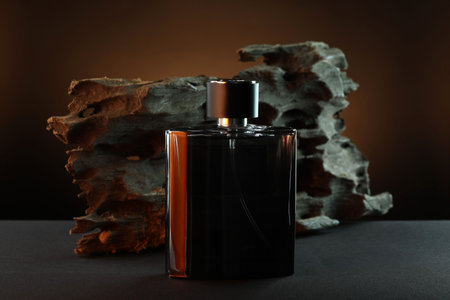 Luxury men`s perfume in bottle on gray table against brown backgroundの写真素材