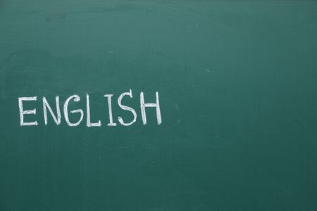 Word English written with chalk on green board. Space for textの写真素材