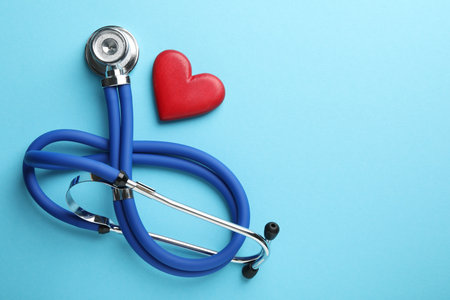 Stethoscope and red heart on light blue background, top view. Space for textの写真素材