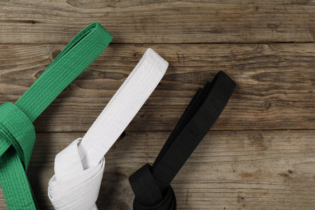 Colorful karate belts on wooden background, flat layの写真素材