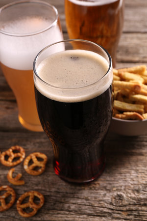 Glasses of beer, pretzel crackers and rusks on wooden table, closeupの写真素材