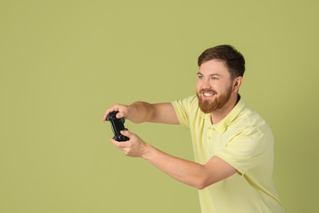 Happy man playing video game with controller on pale green background. Space for textの写真素材