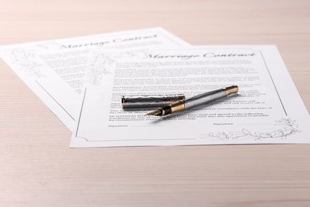 Marriage contracts and pen on light wooden tableの写真素材