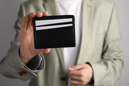 Woman holding leather business card holder with cards on gray background, closeupの写真素材
