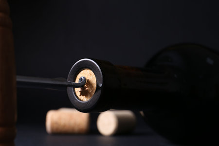 Wine bottle with corkscrew on dark background, closeupの写真素材