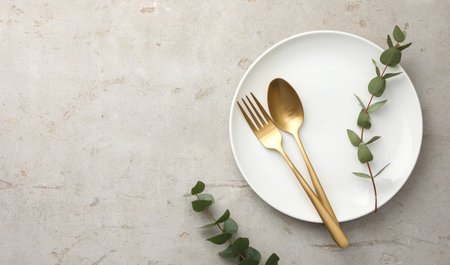 Stylish setting with cutlery, eucalyptus branches and plate on light gray table, top view. Space for textの写真素材