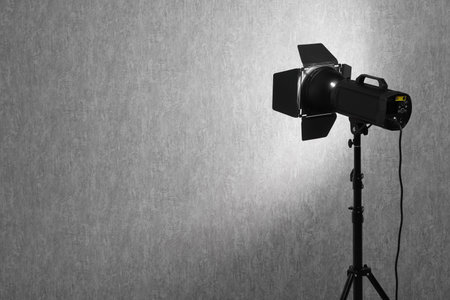 Gray photo background and professional lighting equipment in studio, space for text