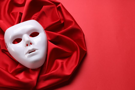 Theater arts. White mask and fabric on red background, above view. Space for textの写真素材