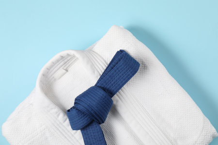 Karate belt and white kimono on light blue background, top viewの写真素材