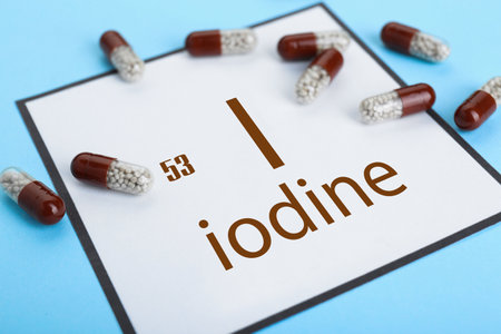 Card with iodine element and pills on light blue background, closeupの写真素材
