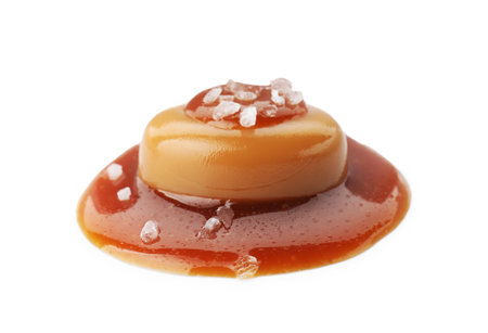 Yummy candy with caramel sauce and sea salt isolated on whiteの写真素材